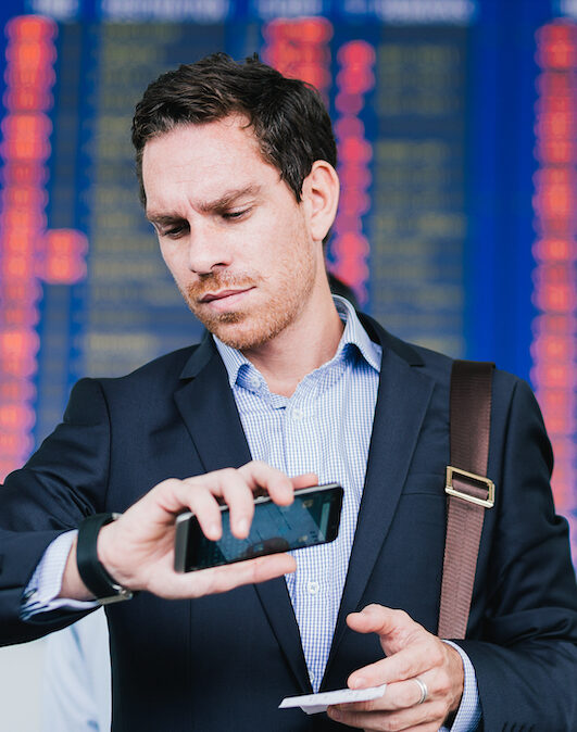 Man looking at watch after 3 hour flight delay